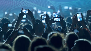 People filming with smartphones during a concert